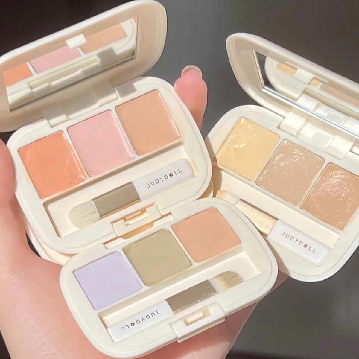 Các Bảng Màu Che Khuyết Điểm Judydoll Ba bảng che khuyết điểm Judydoll mở nắp với các ô màu kem khác nhau